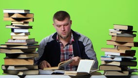Man chooses the most interesting book, and writes in a notebook. Green screen stock video footage Man chooses the most interesting book, and writes in a notebook. Green screen stock video footage