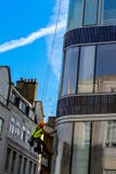 Man climb outside for cleaning window glass of high tower stock photo Man climb outside for cleaning window glass of high tower stock photo
