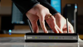 A man connects the ethernet cables to the WAN port and LAN ports of the WiFi router stock video A man connects the ethernet cables to the WAN port and LAN ports of the WiFi router stock video