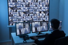Man in control room monitoring cctv footage. Rear View Of A Man In Control Room Monitoring Multiple Cctv Footage Man in control room monitoring cctv footage. Rear View Of A Man In Control Room Monitoring Multiple Cctv Footage