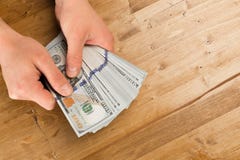 Man count the new us dollars on wooden table stock photography Man count the new us dollars on wooden table stock photography