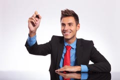 Man at desk writes on imaginary screen stock photo Man at desk writes on imaginary screen stock photo