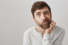 Man do not know how to solve problem. Indoor shot of clueless troubled european guy looking up and squinting, scratching royalty free stock photography Man do not know how to solve problem. Indoor shot of clueless troubled european guy looking up and squinting, scratching royalty free stock photography