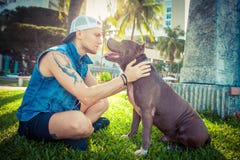 Man and dog american pit bull terrier relaxing at the park embracing and hugging