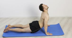 Man doing yoga poses in fitness studio