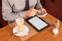 Man drinking coffee and using tablet and mobile stock image Man drinking coffee and using tablet and mobile stock image