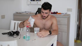 Man drinking protein shaker from blender