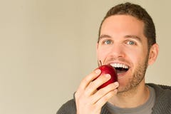 Man with funny face looking at an apple Royalty Free Stock Photos Man with funny face looking at an apple Royalty Free Stock Photos