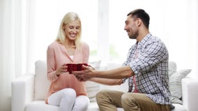 Man giving woman red heart shaped gift box