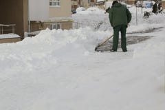 Man in uniform cleaning snow with a shovel royalty free stock photos Man in uniform cleaning snow with a shovel royalty free stock photos