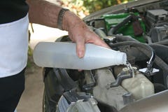 Man hand fill fresh water into radiator of car stock photos Man hand fill fresh water into radiator of car stock photos