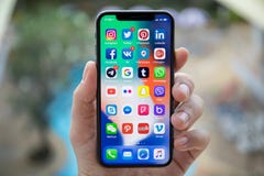 Man hand holding iPhone X with social network on screen