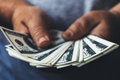 Man hands holding usa dollar banknotes spread out by fan, making cash money success concept. Selective focus on money Stock Image Man hands holding usa dollar banknotes spread out by fan, making cash money success concept. Selective focus on money Stock Image
