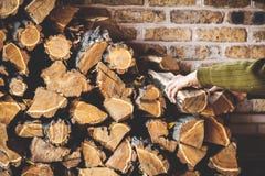 Man hands take log out of folded pile firewood stock images Man hands take log out of folded pile firewood stock images