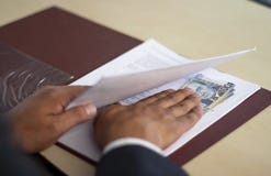 Man hiding bribe under some papers, Peruvian money stock image Man hiding bribe under some papers, Peruvian money stock image