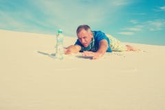 Man Hiker Suffering From Thirst, Creeps To A Bottle Of Water Royalty Free Stock Photography