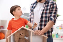 Man and his child playing builders with wooden doll house royalty free stock image Man and his child playing builders with wooden doll house royalty free stock image