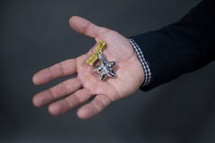 The man is holding a Christmas toy in the palm of a silver star with a bow. royalty free stock images The man is holding a Christmas toy in the palm of a silver star with a bow. royalty free stock images