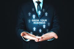 Man Holding Grow Your Business Words With Growth Arrows. Royalty Free Stock Photo