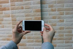 Man holding phone against a brick wall Royalty Free Stock Images Man holding phone against a brick wall Royalty Free Stock Images