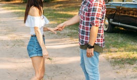 A man holds a girl by the hand, talks, offers marriage.in the background is a black car.offering.girl pulls out her hand, wants to royalty free stock image A man holds a girl by the hand, talks, offers marriage.in the background is a black car.offering.girl pulls out her hand, wants to royalty free stock image