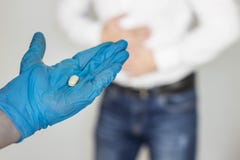 Man holds on to stomach, abdominal pain, hand in glove with a pill, close-up, gastritis stock photos Man holds on to stomach, abdominal pain, hand in glove with a pill, close-up, gastritis stock photos