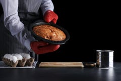 man i m?rk bakgrund f?r r?d potholderinnehavpaj och som isolerar p? svart receptbegrepp med ingredienser p? tabellen arkivfoton man i m?rk bakgrund f?r r?d potholderinnehavpaj och som isolerar p? svart receptbegrepp med ingredienser p? tabellen arkivfoton