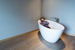 Man inside a luxury bathtub in modern apartment stock photography Man inside a luxury bathtub in modern apartment stock photography
