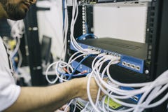 Man installing cables in server rack Man installing cables in server rack
