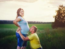 https://thumbs.dreamstime.com/t/man-kissing-pregnant-belly-his-wife-outdoors-husband-field-sun-flaress-beautiful-women-smiling-looking-camera-74060382.jpg