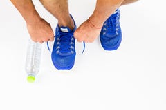 Man lacing sport shoes with water bottle on white background stock image Man lacing sport shoes with water bottle on white background stock image
