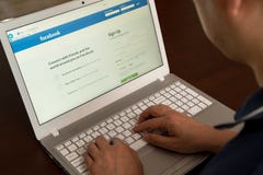 A man is logged into Facebook with a laptop. stock photography A man is logged into Facebook with a laptop. stock photography