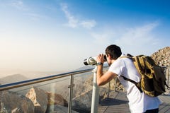 Man using public binoculars at the mountain top Stock Image Man using public binoculars at the mountain top Stock Image