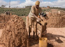 Man making bricks from clay, by hand in Madagascar