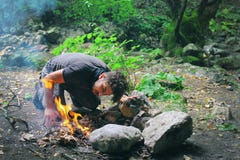 Man making fire in countryside Man making fire in countryside