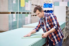 Man Measures With Roulette Drywall Sheets In Store Building Mate Royalty Free Stock Photography