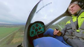 Man piloting plane over countryside. Middle age male pilot controlling aircraft during flight over countryside on cloudy day stock video footage Man piloting plane over countryside. Middle age male pilot controlling aircraft during flight over countryside on cloudy day stock video footage