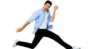 Man playing air guitar on white background