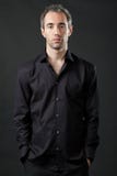 Man posing in black shirt on dark background. Handsome man posing in black shirt on dark background in studio Stock Image Man posing in black shirt on dark background. Handsome man posing in black shirt on dark background in studio Stock Image