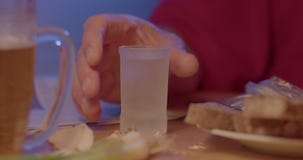 man pours alcoholic liquid in glass drinking. He takes hand in fingers.