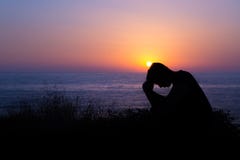 Man Praying by the Sea at Sunset stock photos Man Praying by the Sea at Sunset stock photos