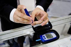 Man pricking a finger for measuring glucose level in his blood drop by using digital glucometer royalty free stock photography Man pricking a finger for measuring glucose level in his blood drop by using digital glucometer royalty free stock photography