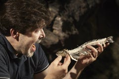 Man relaxing in wilderness and eating hunted fish stock photography Man relaxing in wilderness and eating hunted fish stock photography