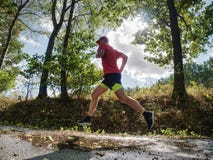 Man runner in yellow black shorts pants and red t-shirt is jumping stock images Man runner in yellow black shorts pants and red t-shirt is jumping stock images