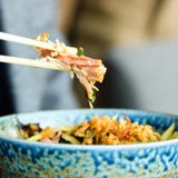 Man`s hand holding chopsticks over a plate of Japanese, thai, chinese meal - rice, mushroom, vegetables. Cafe Royalty Free Stock Photo Man`s hand holding chopsticks over a plate of Japanese, thai, chinese meal - rice, mushroom, vegetables. Cafe Royalty Free Stock Photo