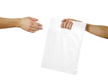 A man`s hand passes a white plastic bag. Close up. Isolated on white background stock photos A man`s hand passes a white plastic bag. Close up. Isolated on white background stock photos