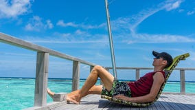 Man sits in over water bar on luxury island resort in Maldives. royalty free stock photo Man sits in over water bar on luxury island resort in Maldives. royalty free stock photo