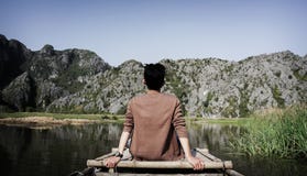 Man Sitting on Bridge Front of Mountain Stock Image Man Sitting on Bridge Front of Mountain Stock Image