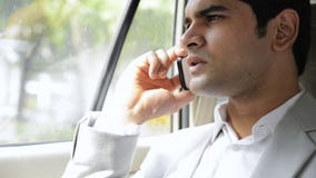 Man sitting in a car and talking on a mobile phone