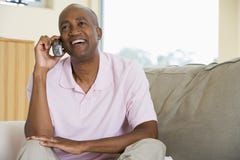 Man sitting in living room using telephone